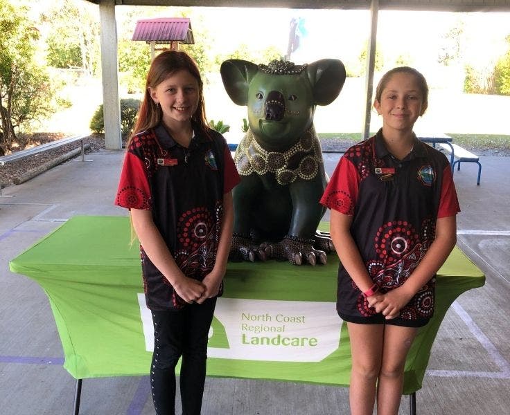 two_students_with_koala_statue